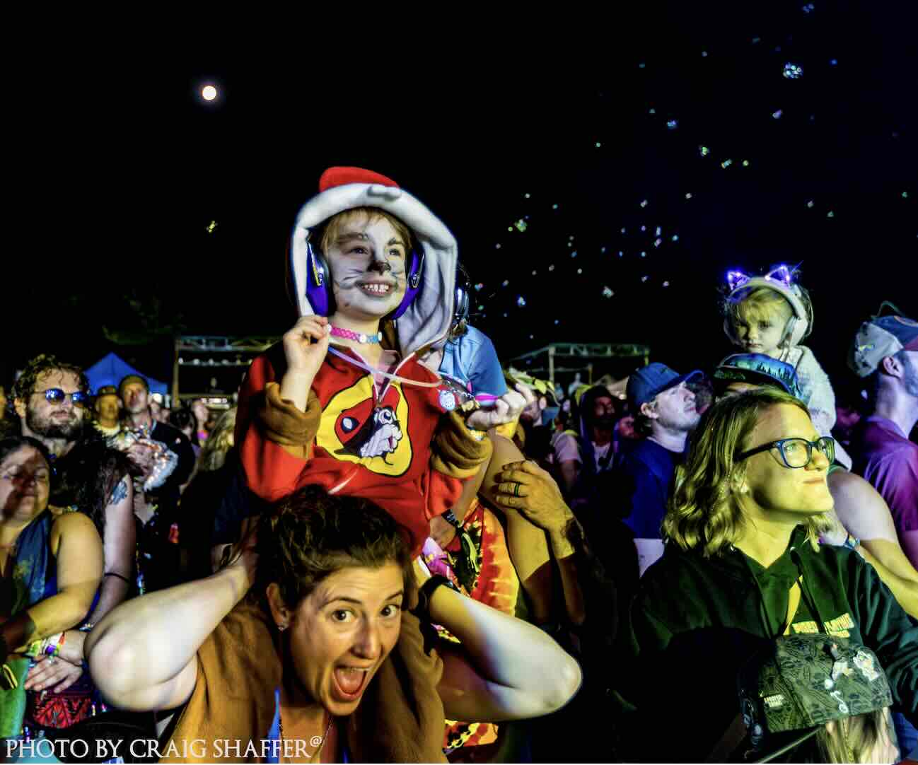 girl on moms shoulders in costume at domefest 2025