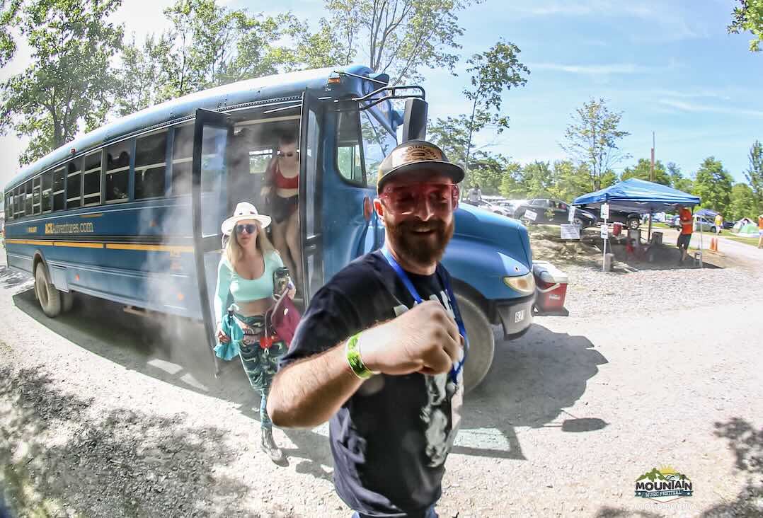 guest getting off the shuttle bus at mountain music festival at ace adventure resort in the new river gorge